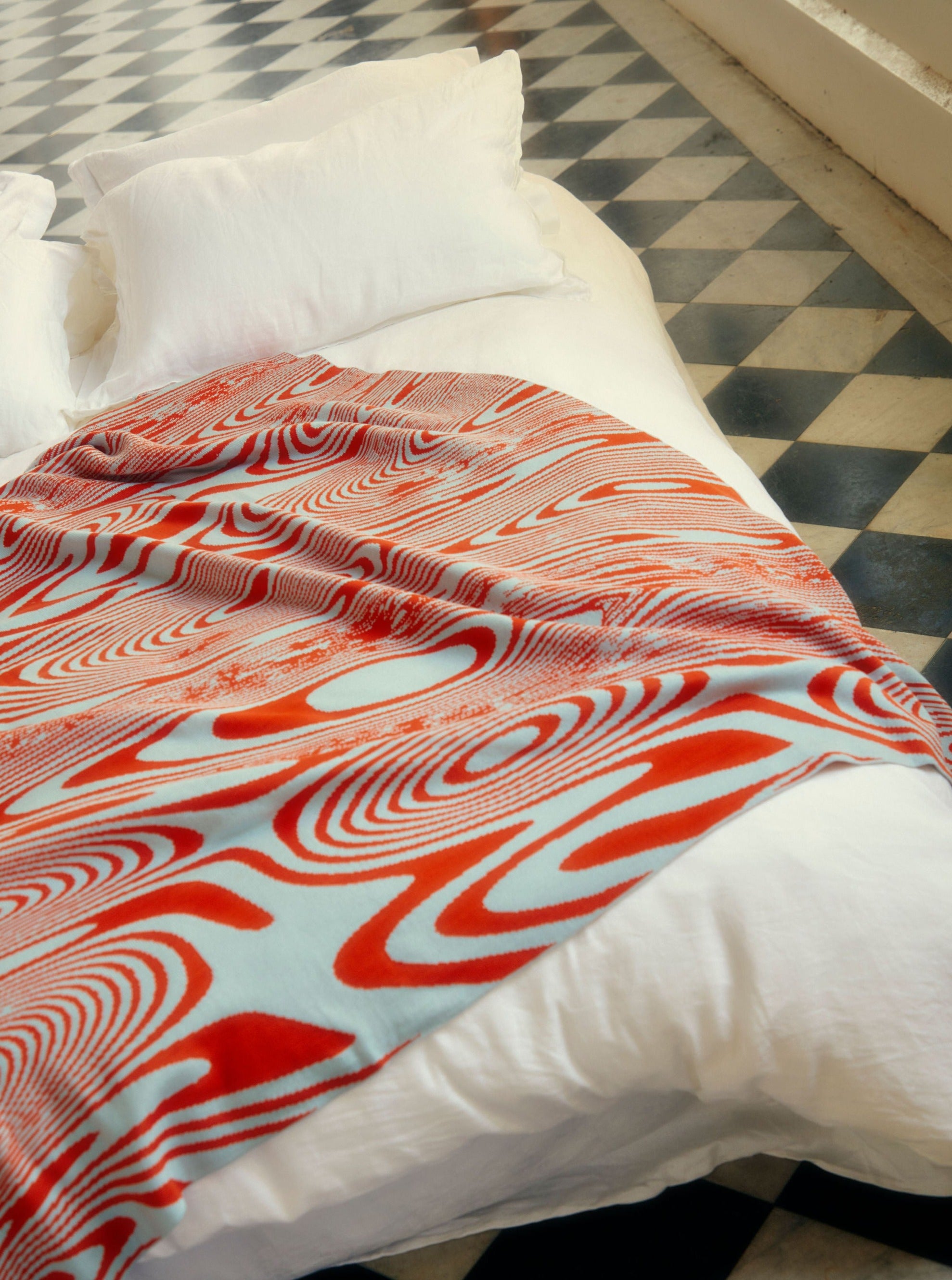 The Swirly blanket is a magical pattern pattern blends and turns it creates a sense of an optical illusion, playing tricks on your brain about perception. Bright orange x ice blue. Made from the finest Australian Merino wool. 